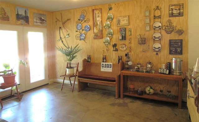 sitting room with french doors and wooden walls