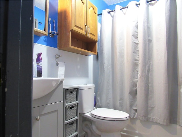 bathroom with toilet, walk in shower, and vanity