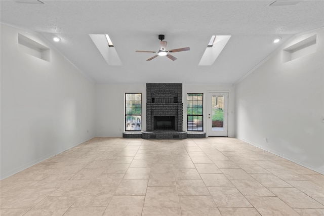 unfurnished living room with a fireplace, a healthy amount of sunlight, a ceiling fan, and vaulted ceiling with skylight