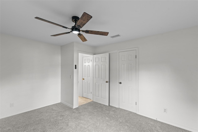 unfurnished bedroom with visible vents, ceiling fan, carpet, and baseboards