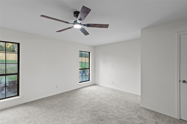 spare room with carpet flooring, ceiling fan, and baseboards