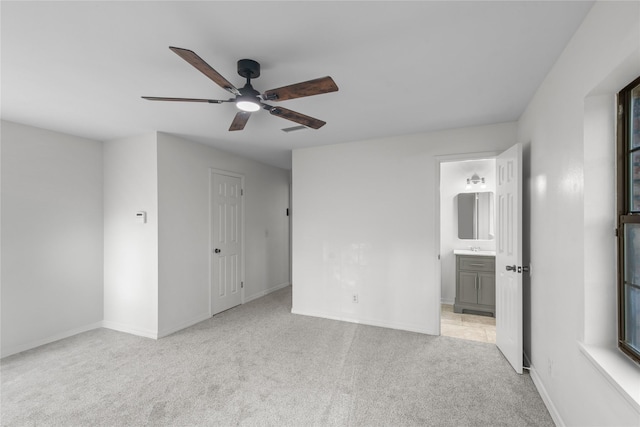 unfurnished bedroom featuring connected bathroom, ceiling fan, carpet flooring, baseboards, and visible vents