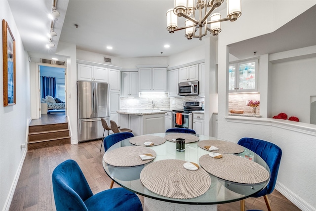 dining room featuring hardwood / wood-style floors and an inviting chandelier