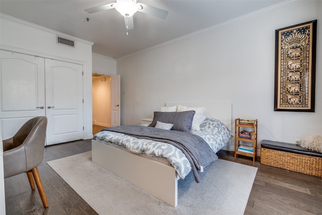 bedroom with hardwood / wood-style floors, a closet, ceiling fan, and crown molding