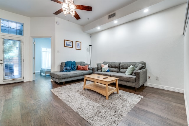 living room with ceiling fan and dark wood-type flooring