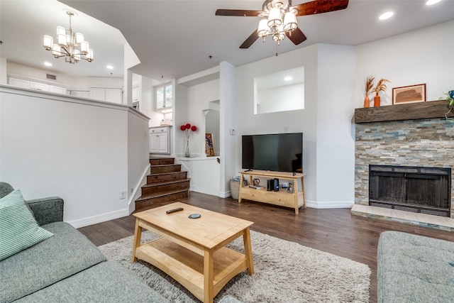 living room with a fireplace, dark hardwood / wood-style flooring, and ceiling fan with notable chandelier