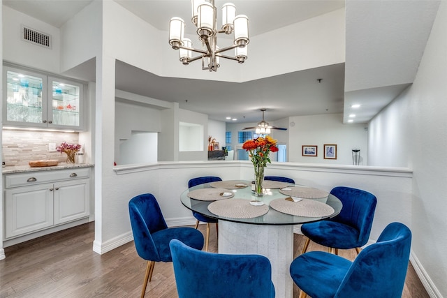 dining room featuring ceiling fan with notable chandelier and dark hardwood / wood-style floors