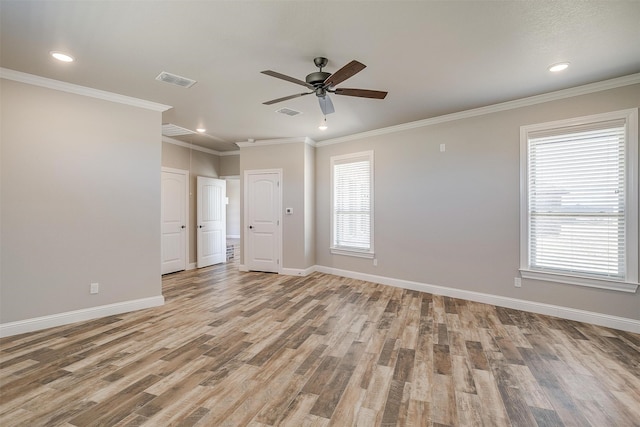 empty room with ornamental molding and light wood-type flooring