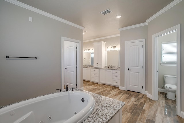 bathroom with toilet, a bathing tub, vanity, crown molding, and hardwood / wood-style flooring