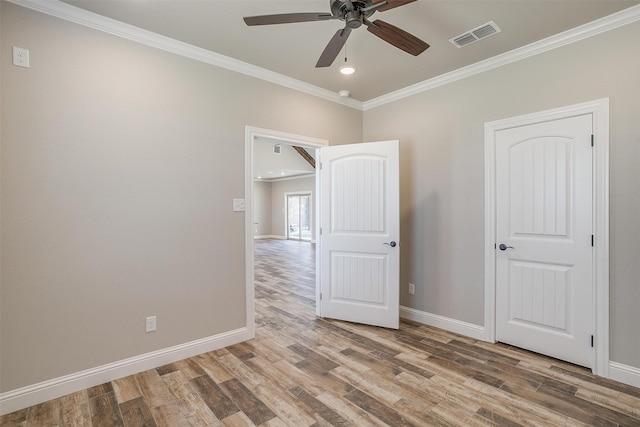 unfurnished room with crown molding, wood-type flooring, and ceiling fan