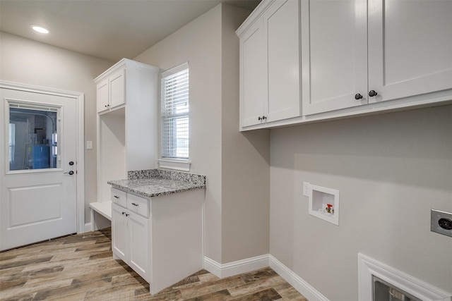 washroom featuring cabinets, hookup for an electric dryer, hookup for a washing machine, and light wood-type flooring