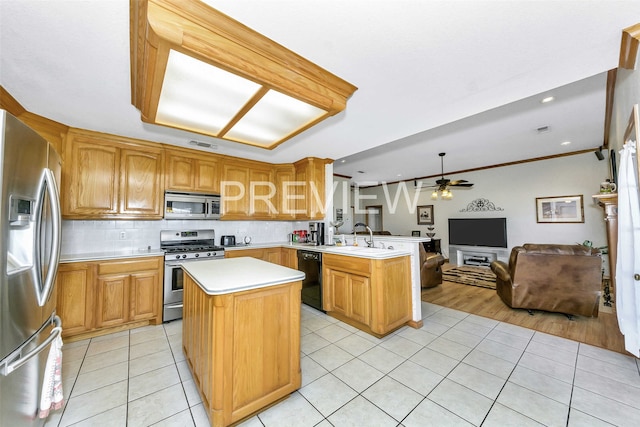 kitchen with crown molding, light tile patterned floors, appliances with stainless steel finishes, a kitchen island, and kitchen peninsula