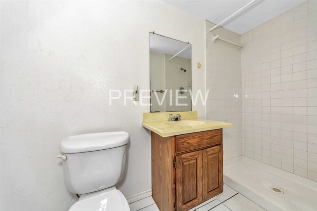 bathroom featuring tile patterned floors, vanity, a tile shower, and toilet