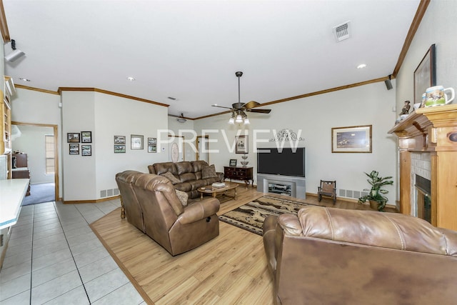 tiled living room featuring a tile fireplace, ceiling fan, and ornamental molding