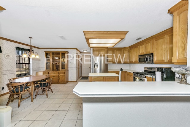 kitchen featuring crown molding, decorative light fixtures, appliances with stainless steel finishes, a notable chandelier, and kitchen peninsula