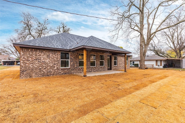 rear view of property with a yard and a patio area