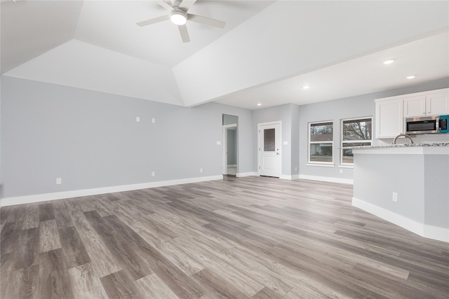 unfurnished living room featuring ceiling fan and light wood-type flooring