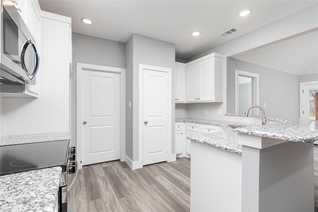 kitchen with white cabinetry, sink, light hardwood / wood-style floors, and range