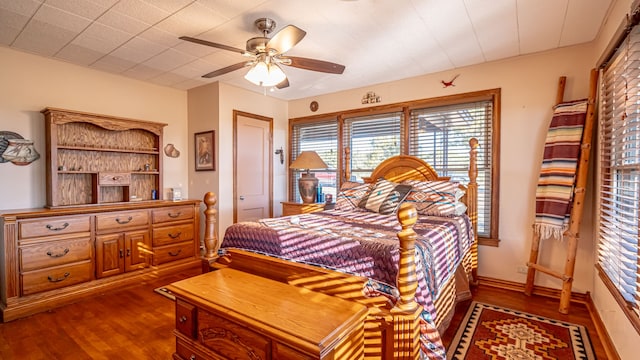 bedroom with dark hardwood / wood-style floors and ceiling fan