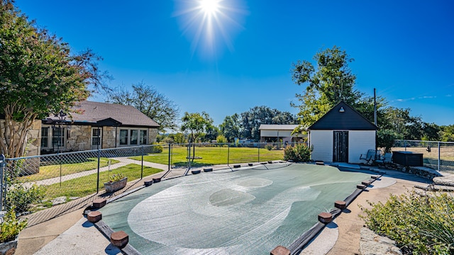 view of community with an outdoor structure, basketball court, and a lawn