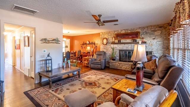 living room featuring hardwood / wood-style floors, a healthy amount of sunlight, a textured ceiling, and a fireplace