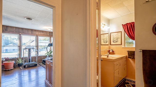 bathroom with hardwood / wood-style floors and tile walls