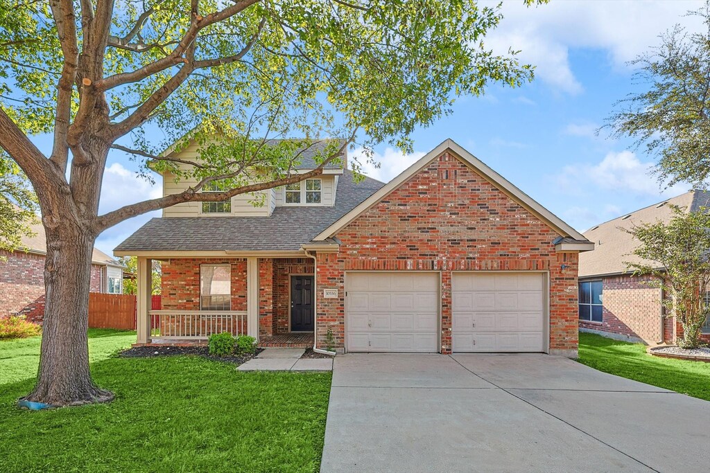 view of front property featuring covered porch, a garage, and a front lawn