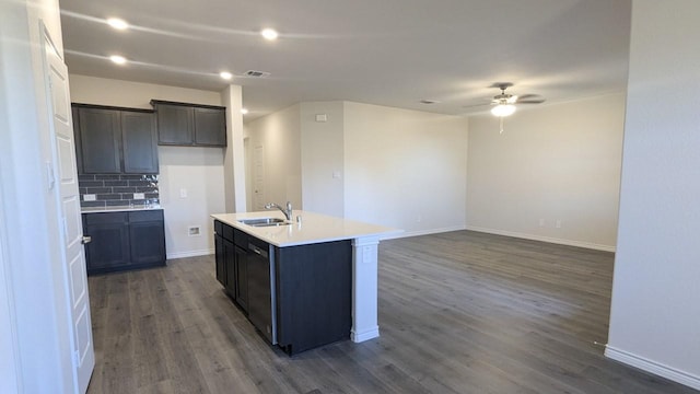 kitchen featuring dark hardwood / wood-style floors, an island with sink, sink, backsplash, and ceiling fan