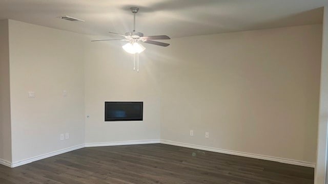 unfurnished living room featuring dark wood-type flooring and ceiling fan