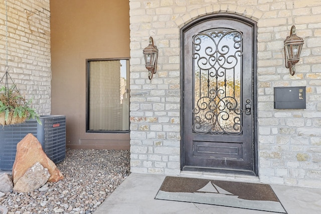 doorway to property with central AC unit