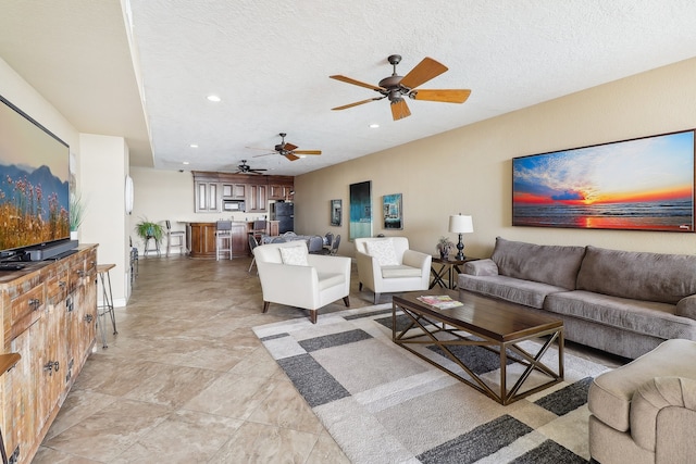 living room with a textured ceiling and ceiling fan