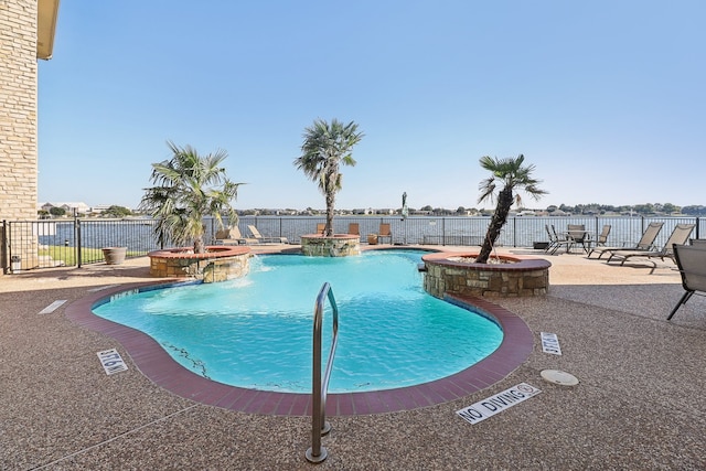 view of pool with a patio area, pool water feature, and a jacuzzi