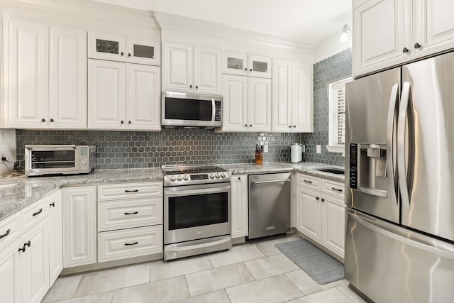 kitchen with white cabinetry, stainless steel appliances, and tasteful backsplash