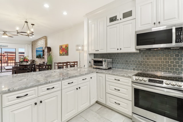 kitchen with white cabinets, light stone counters, stainless steel appliances, and light tile patterned floors