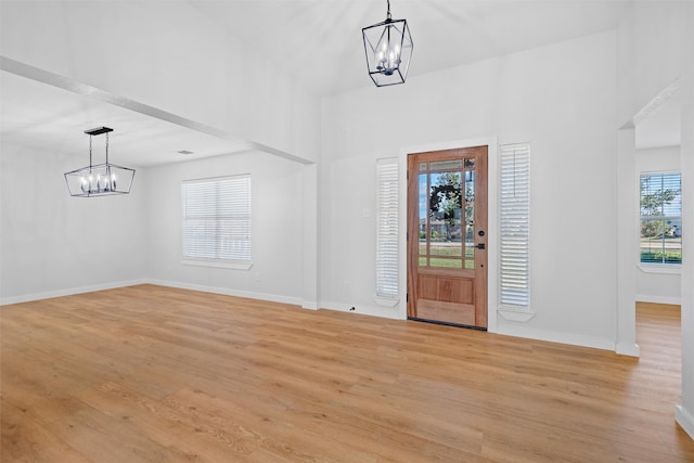 foyer featuring an inviting chandelier, light hardwood / wood-style flooring, and plenty of natural light