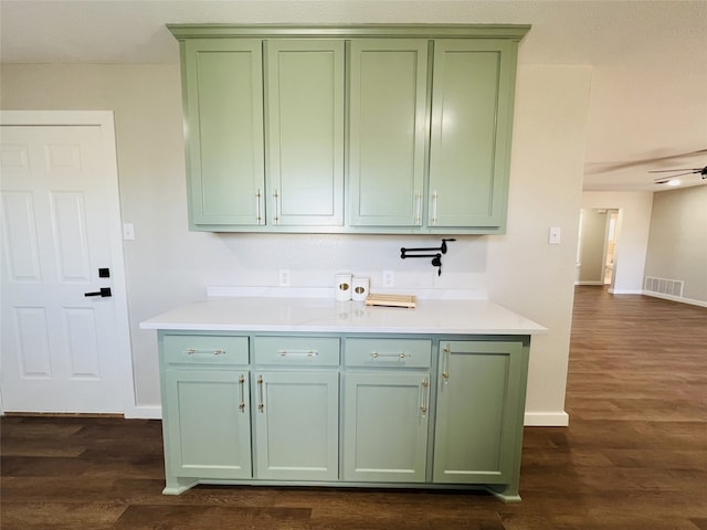 kitchen with ceiling fan, green cabinets, and dark hardwood / wood-style flooring