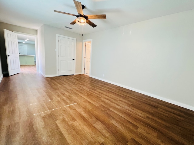 empty room with hardwood / wood-style floors and ceiling fan