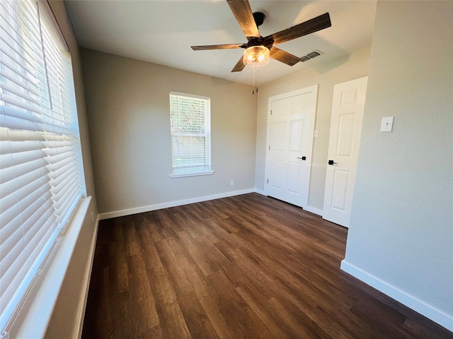 unfurnished bedroom with dark hardwood / wood-style flooring, a closet, and ceiling fan