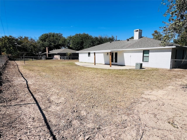 back of property with a patio area, a yard, and cooling unit