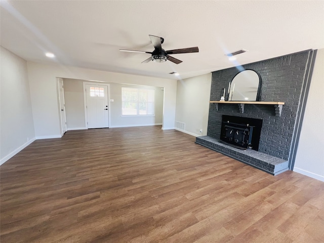 unfurnished living room featuring hardwood / wood-style floors, a fireplace, and ceiling fan