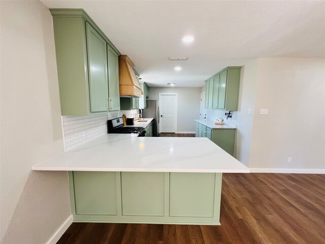 kitchen featuring electric range, kitchen peninsula, and green cabinets