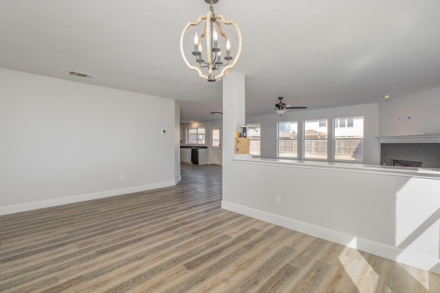 unfurnished living room with wood-type flooring and ceiling fan with notable chandelier