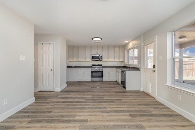 kitchen featuring white cabinetry, stainless steel appliances, sink, and hardwood / wood-style floors