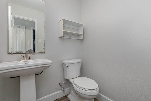 bathroom with wood-type flooring and toilet