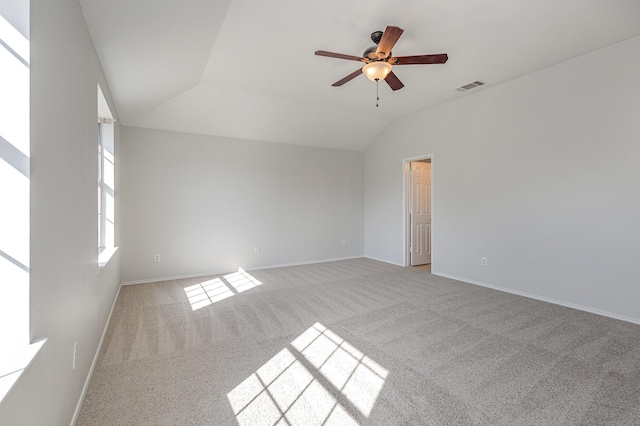 carpeted spare room featuring lofted ceiling and ceiling fan