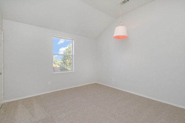 empty room with vaulted ceiling and carpet floors