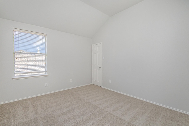 carpeted empty room featuring lofted ceiling