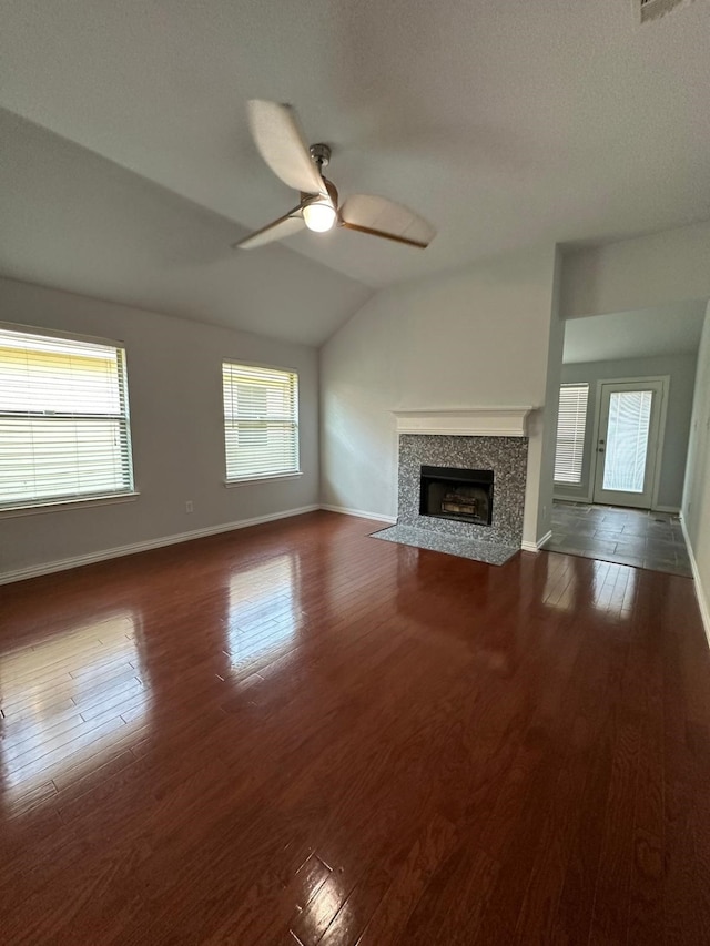 unfurnished living room featuring lofted ceiling, dark wood-type flooring, and ceiling fan