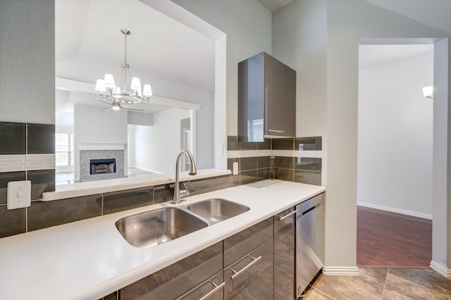 kitchen featuring wood-type flooring, sink, decorative light fixtures, an inviting chandelier, and stainless steel dishwasher