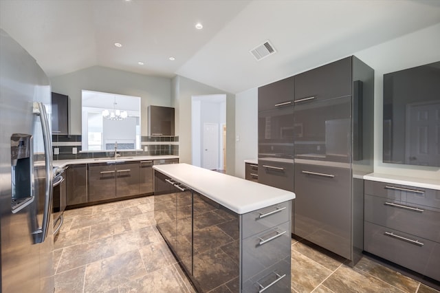 kitchen with lofted ceiling, stainless steel fridge with ice dispenser, an inviting chandelier, sink, and a center island